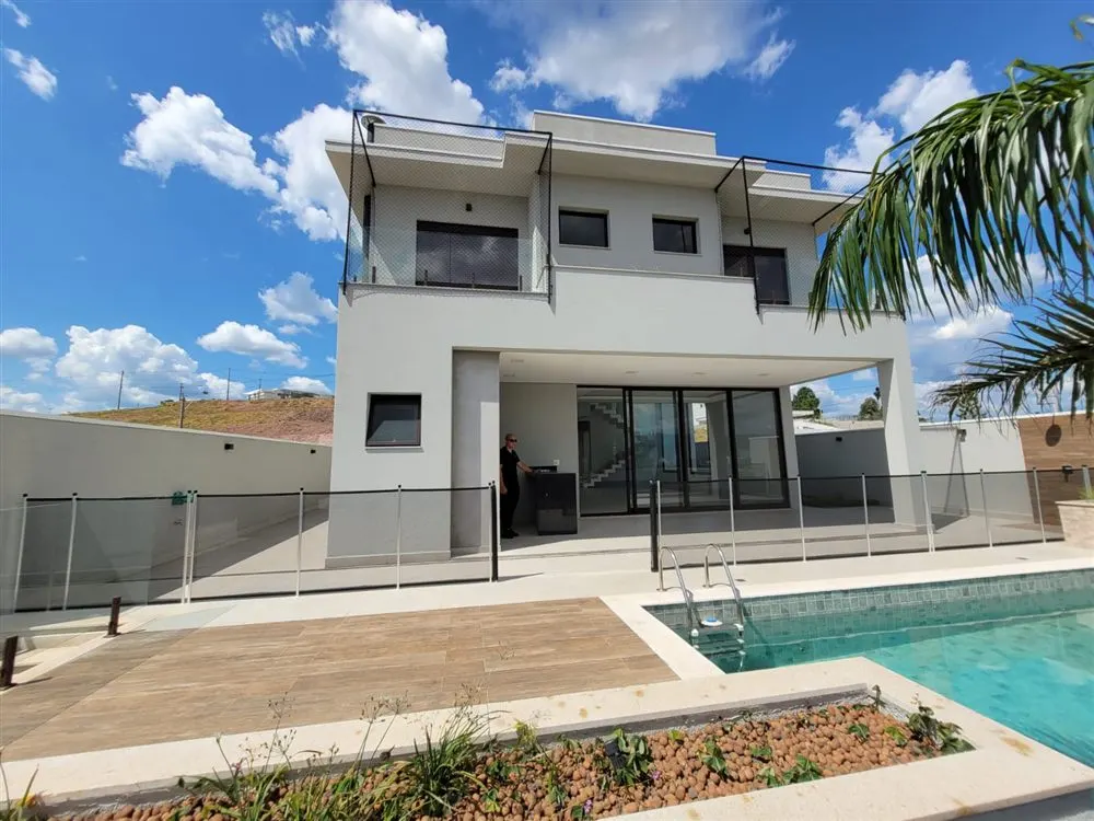 Casa de dois andares com redes de proteção nas sacadas e cerca removível na piscina