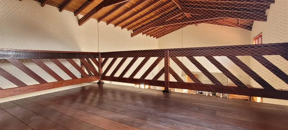 Mezanino de madeira com rede de proteção transparente instalada no guarda-corpo