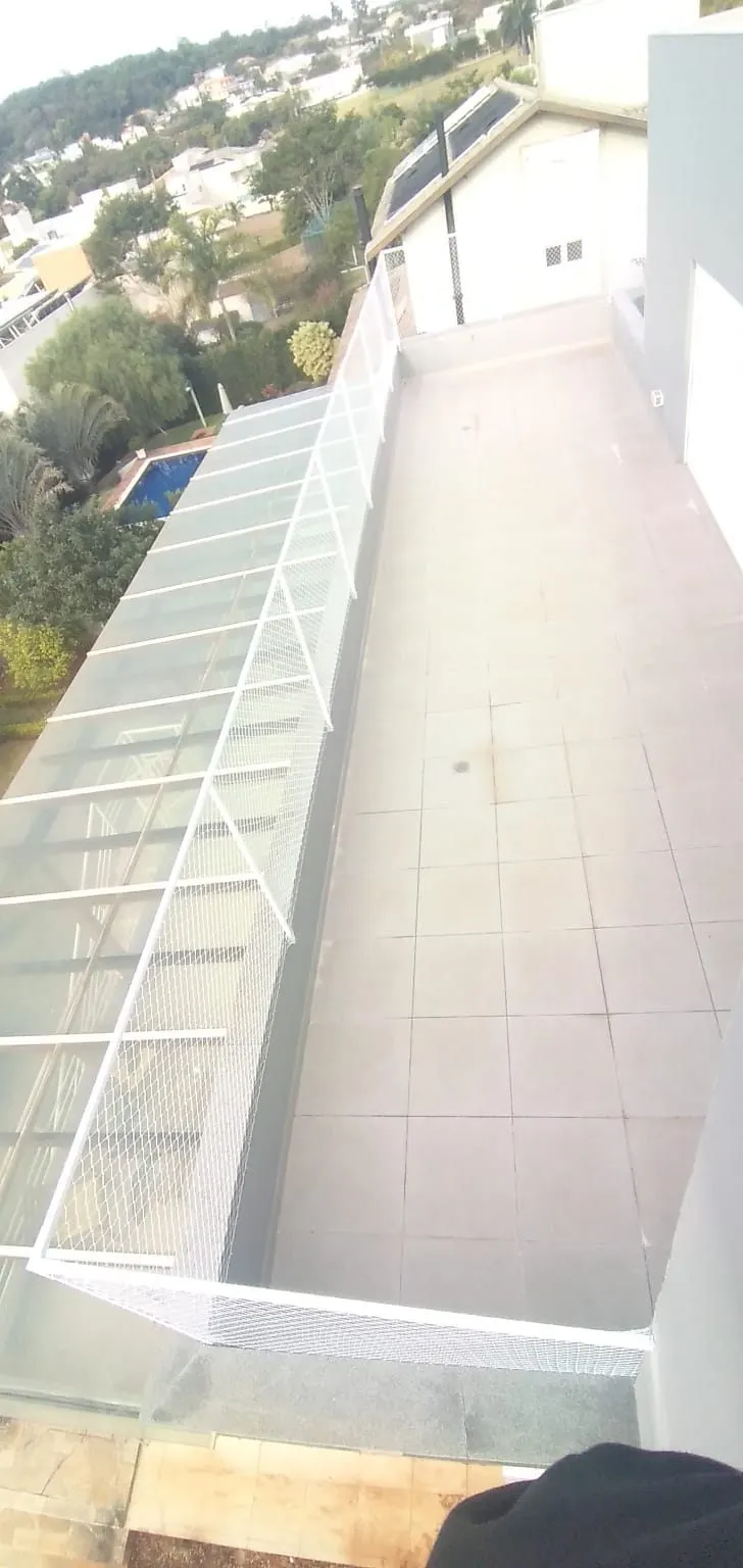 Cobertura de vidro protegida com rede branca instalada pela Barbosa