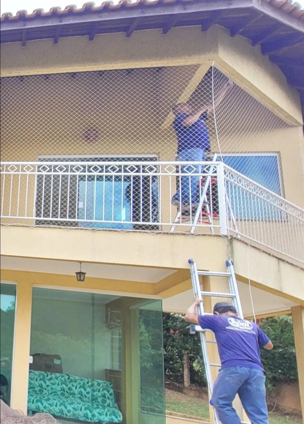 Equipe da Barbosa instalando rede de proteção em varanda de casa